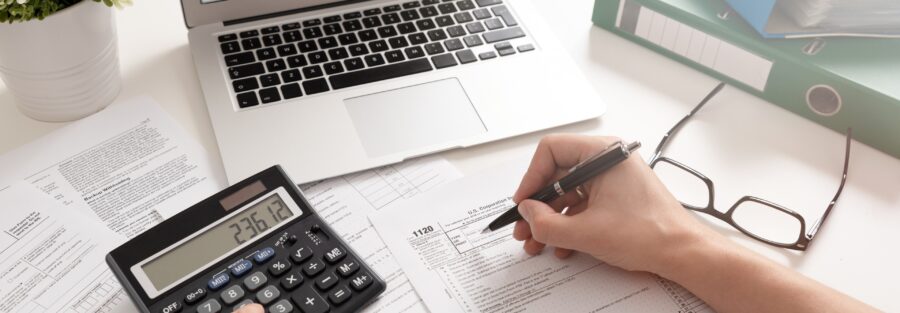 Persona analizando el presupuesto de una empresa con gráficos financieros y ordenador portátil